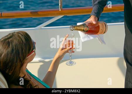 Ein Chartergast, der ein Glas Alfred Rothschild rosa Champagner gegossen hat Stockfoto