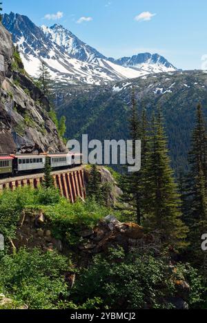 Ein landschaftlich reizvoller Personenzug, der eine Kurve hoch in den Bergen über Skagway, Alaska, umrundet Stockfoto