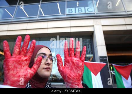 Birmingham, England, Großbritannien. Oktober 2024. Ein Demonstrant hält rote Hände hoch, die das Blut an den Händen der Medien während der Demonstration zeigen. Demonstranten versammeln sich, um gegen die BBC und die Western Media zu marschieren. Die Demonstranten argumentieren, dass die Medien nicht einmal überliefert wurden, wenn sie Nachrichten aus dem Nahen Osten berichteten, was die Ereignisse in Gaza und im Libanon zugunsten des israelischen Regimes verzerrt. Sie glauben, dass dieses Verhalten diese Organisationen zu Komplizen an dem, was sie als Völkermord am palästinensischen Volk betrachten. Stockfoto