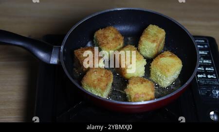 Goldbraune Kroketten, die in einer Pfanne frittieren Stockfoto