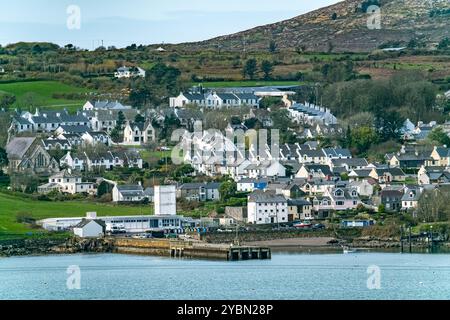 Eine Küstenlandschaft mit Häusern am Rande einer Halbinsel. Die Häuser sind überwiegend weiß und haben schwarze Dächer. Es gibt einen felsigen beac Stockfoto
