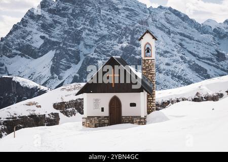 Cappella degli Alpini, eine kleine Kapelle auf verschneiten Bergen in der Nähe der drei Zinnen. Stockfoto