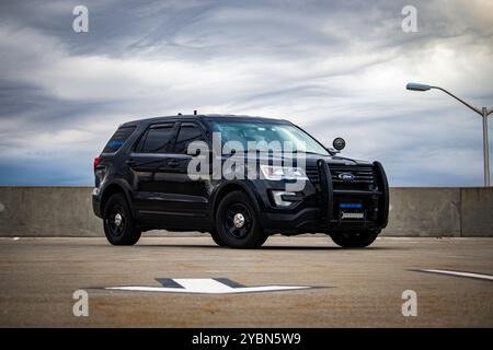 Amerikanischer Polizist, Ford Police Interceptor Utility, auf Parkgarage mit bewölktem Himmel Stockfoto