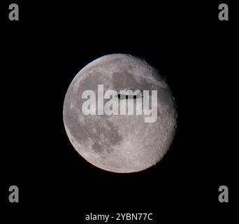 Wimbledon, London, Großbritannien. Oktober 2024. Flugzeuge, die sich dem Flughafen Heathrow nähern, überqueren den abnehmenden Gibbous Mond. Quelle: Malcolm Park/Alamy Live News Stockfoto