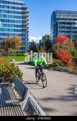 Männlicher Radfahrer in gelber Jacke auf einem speziellen Radweg in Vancouver Stockfoto