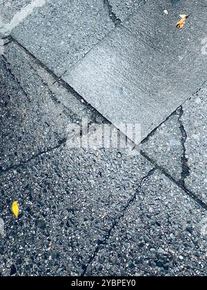 Nahaufnahme eines gerissenen und verwitterten Teils eines Gehsteigs aus Beton, 2024, New York City, USA Stockfoto