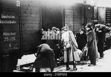 Ein SS-Mitglied überwacht die Einschiffung von Juden in Züge während einer Deportationsaktion im Krakauer Ghetto. Das Krakauer Ghetto wurde 1942/43 liquidiert und fast alle Einwohner wurden nach Belzec und Auschwitz geschickt. Einige der fähigen Menschen wurden in Sklavenarbeitslager geschickt. Stockfoto