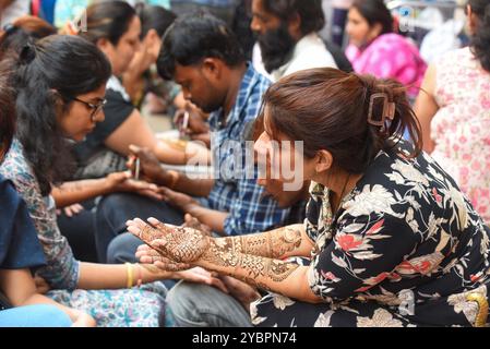 GURUGRAM, INDIEN - 19. OKTOBER: Eine Frau wendet am Vorabend des Karva Chauth Festivals im Sadar Bazar nahe der Government Girls Senior Secondary School, Jacobpura, am 19. Oktober 2024 in Gurugram, Indien, Henna an. Karva Chauth ist ein eintägiges Festival, das jährlich von verheirateten Hindu-Frauen gefeiert wird, bei dem sie ein Fasten von Sonnenaufgang bis Mondaufgang beobachten und für das Wohlbefinden und die Langlebigkeit ihrer Ehemänner beten. Das Festival wird auch von unverheirateten Frauen beobachtet, die in der Hoffnung beten, einen gewünschten Lebenspartner zu bekommen. (Foto: Parveen Kumar/Hindustan Times/SIPA USA ) Stockfoto