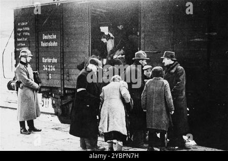 Ein SS-Mitglied überwacht die Einschiffung von Juden in Züge während einer Deportationsaktion im Krakauer Ghetto. Das Krakauer Ghetto wurde 1942/43 liquidiert und fast alle Einwohner wurden nach Belzec und Auschwitz geschickt. Einige der fähigen Menschen wurden in Sklavenarbeitslager geschickt. Stockfoto