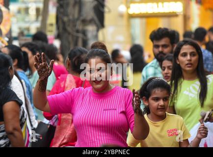 GURUGRAM, INDIEN - 19. OKTOBER: Eine Frau wendet am Vorabend des Karva Chauth Festivals im Sadar Bazar nahe der Government Girls Senior Secondary School, Jacobpura, am 19. Oktober 2024 in Gurugram, Indien, Henna an. Karva Chauth ist ein eintägiges Festival, das jährlich von verheirateten Hindu-Frauen gefeiert wird, bei dem sie ein Fasten von Sonnenaufgang bis Mondaufgang beobachten und für das Wohlbefinden und die Langlebigkeit ihrer Ehemänner beten. Das Festival wird auch von unverheirateten Frauen beobachtet, die in der Hoffnung beten, einen gewünschten Lebenspartner zu bekommen. (Foto: Parveen Kumar/Hindustan Times/SIPA USA ) Stockfoto