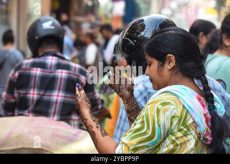 GURUGRAM, INDIEN - 19. OKTOBER: Eine Frau wendet am Vorabend des Karva Chauth Festivals im Sadar Bazar nahe der Government Girls Senior Secondary School, Jacobpura, am 19. Oktober 2024 in Gurugram, Indien, Henna an. Karva Chauth ist ein eintägiges Festival, das jährlich von verheirateten Hindu-Frauen gefeiert wird, bei dem sie ein Fasten von Sonnenaufgang bis Mondaufgang beobachten und für das Wohlbefinden und die Langlebigkeit ihrer Ehemänner beten. Das Festival wird auch von unverheirateten Frauen beobachtet, die in der Hoffnung beten, einen gewünschten Lebenspartner zu bekommen. (Foto: Parveen Kumar/Hindustan Times/SIPA USA ) Stockfoto