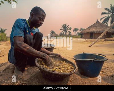 République Démocratique du Congo, Tshikenda, 24.08.2023. Kabuayi Bomba, Agriculteur du Kasai Central, fait le vannage de ses haricots dans un van dans Stockfoto