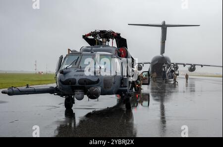 Zwei HH-60G Pave Hawk Hubschrauber warten darauf, in die Rückseite eines C-17 Globemaster III Flugzeugs auf der Patrick Space Force Base, Florida, am 7. Oktober 2024, in Erwartung des Hurrikans Milton geladen zu werden. In weniger als 24 Stunden wurden die Flugzeuge vorbereitet, inspiziert und an einen anderen Ort geflogen, was die Bereitschaft des Flügels für schnelle Rettungseinsätze demonstrierte. (Foto der U.S. Air Force von Tech. Sgt. Darius Sostre-Miroir) Stockfoto