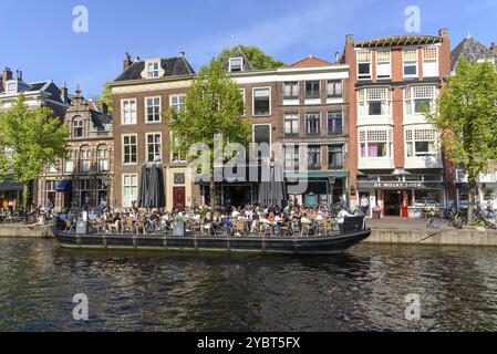 Leiden, Niederlande, 6. Mai 2022: Bootsterrasse voller Menschen, die die Sonne, Essen und Getränke genießen. Das Café im Freien ist eine wichtige Freizeitbeschäftigung Stockfoto