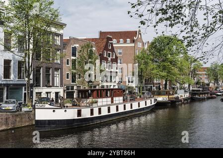 Amsterdam, Niederlande, 7. Mai 2022: Malerischer Blick auf den Kanal mit typisch holländischen Häusern und Bootshäusern am frühen Morgen Stockfoto