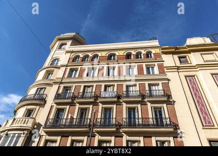 Madrid, Spanien, 1. November 2020: Altes Wohngebäude mit eisernen Balkonen in der Innenstadt von Madrid. Niedrigwinkelansicht gegen den Himmel, Europa Stockfoto