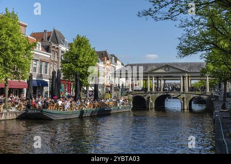 Leiden, Niederlande, 6. Mai 2022: Bootsterrasse voller Menschen, die die Sonne, Essen und Getränke genießen. Das Café im Freien ist eine wichtige Freizeitbeschäftigung Stockfoto