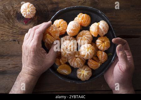 Präsentation von geschälten Mandarinen auf alten Holztisch Stockfoto