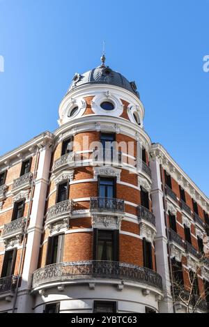 Altes, luxuriöses Backsteingebäude mit Balkonen im historischen Zentrum von Madrid. Blick auf den blauen Himmel. Konzept Mietordnung Stockfoto