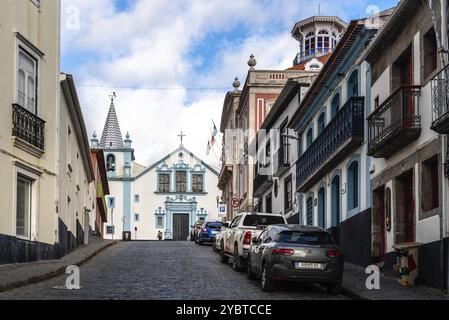 Angra do Heroismo, Portugal, 1. Juli 2022: Steile Kopfsteinpflasterstraße im historischen Zentrum von Angra do Heroismo mit Kolonialhäusern und Heiligtum von Stockfoto