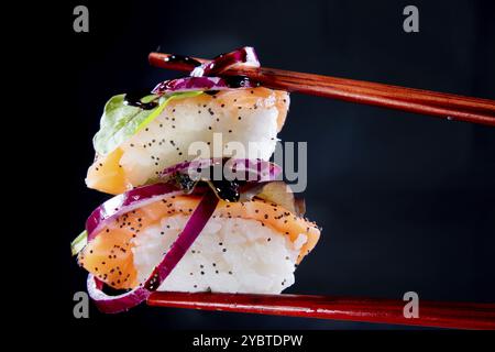 Präsentation einer Portion Sushi mit Beilage auf der Basis roter Zwiebeln Stockfoto