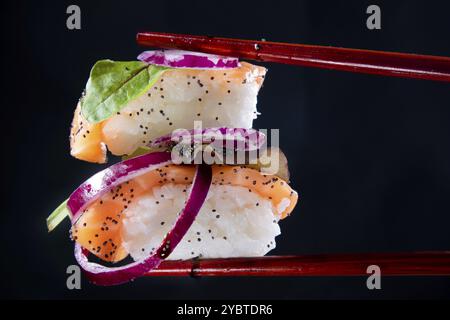 Präsentation einer Portion Sushi mit Beilage auf der Basis roter Zwiebeln Stockfoto