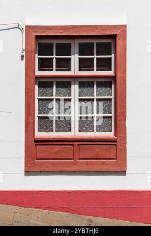 Traditionelles rot gestrichenes Fenster in einem kanarischen Haus im Kolonialstil in der Altstadt von Santa Cruz de La Palma, im ebenfalls bekannten Viertel San Sebastian Stockfoto