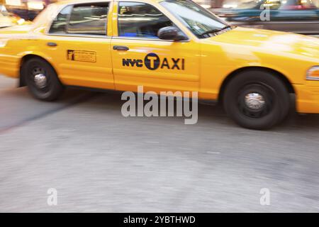 Gelbe Taxikabine in Bewegung, am Times Square, New York City, New York, USA. Die Taxistände von New York City sind weithin bekannte Wahrzeichen der Stadt Stockfoto