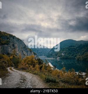 Wege einer geschwungenen Schotterstraße und des Flusses Drina an einem bewölkten Herbstmorgen, Bosnien und Herzegowina Stockfoto