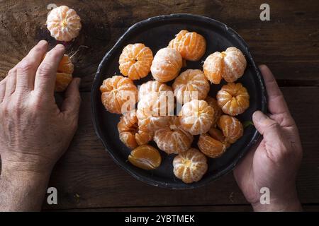 Präsentation von geschälten Mandarinen auf alten Holztisch Stockfoto