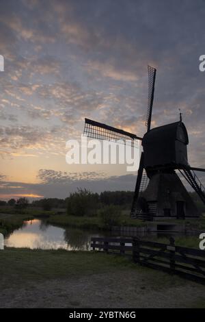 Windmühle die Noordenveldse Molen, die kurz vor Sonnenuntergang gesehen wird, liegt zwischen den niederländischen Dörfern Dussen und Almkerk in der Provinz Noord-Brabant Stockfoto