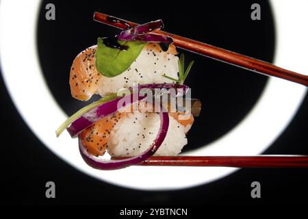 Präsentation einer Portion Sushi mit Beilage auf der Basis roter Zwiebeln Stockfoto