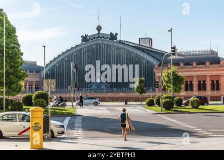 Madrid, Spanien, 1. Mai 2021: Außenansicht des alten Bahnhofs Atocha. Frau, die die Straße vor dem Bahnhof überquert, Europa Stockfoto