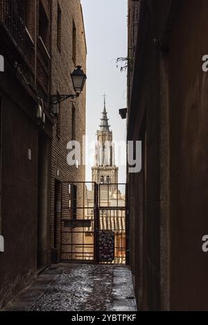 Toledo, Spanien, 19. Februar 2023: Blick auf den Turm der Kathedrale von Toledo durch eine enge Gasse in der mittelalterlichen Stadt, Europa Stockfoto