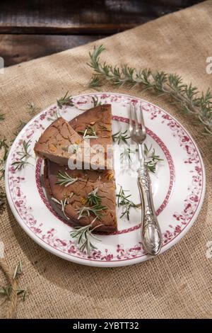 Präsentation eines Kuchens aus Kastanienmehl mit Rosmarinzweigen Stockfoto