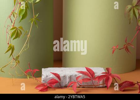 Herbstpodium aus Stein und grünen Blättern auf grünem Hintergrund. Showcase, Produktpräsentation. Eine minimalistische Branding-Szene Stockfoto