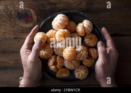 Präsentation von geschälten Mandarinen auf alten Holztisch Stockfoto