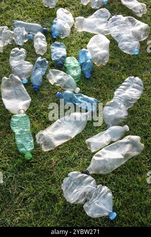 Zeichen der Unhöflichkeit benutzte Plastikflaschen, die auf einer Wiese abgelegt wurden Stockfoto