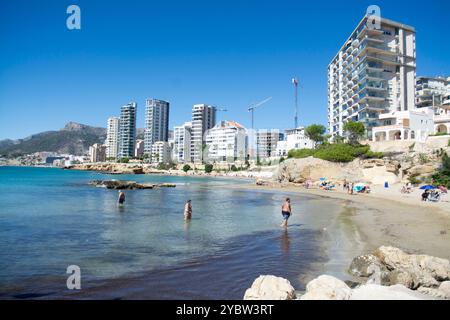Sonnenanbeter am Sandstrand am Mittelmeer in der Stadt Calpe in der spanischen Provinz Alicante Stockfoto