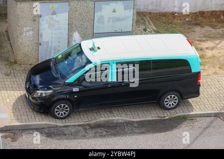 Ein Taxi in schwarz-blauem lissabon parkt auf dem Bürgersteig Stockfoto