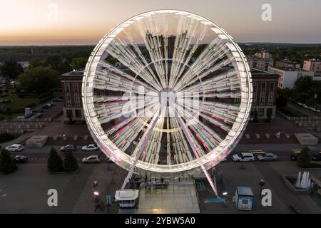 Buntes Riesenrad aus der Vogelperspektive bei Nacht. Großes farbenfrohes Riesenrad im Stadtzentrum. Luftaufnahme der Drohne auf dem farbenfrohen Riesenrad sp Stockfoto