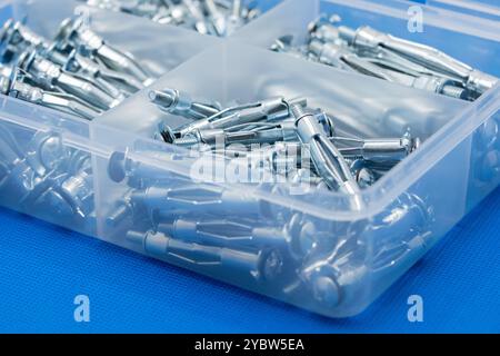 Organizer Box mit Erweiterungsschrauben auf blauem Hintergrund Stockfoto