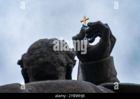 Hüter des Glaubens: Teil des Svetozar-Miletić-Denkmals mit dem Heiligen Kreuz gegen den bedeckten Himmel – Novi Sad 2024 Stockfoto