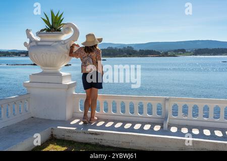 Touristen Frau genießt den Meerblick auf der Promenade der Insel La Toja, Galicien. Stockfoto