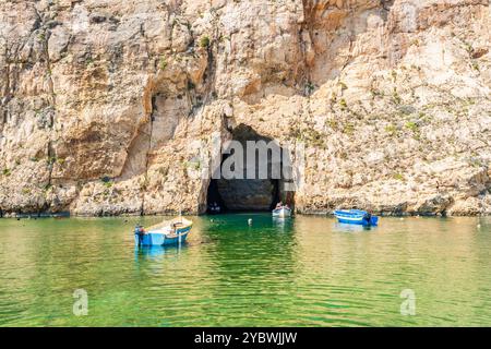 DWEJRA, GOZO, MALTA - 01. SEPTEMBER 2024: Kleine Boote bringen Touristen durch den Meertunnel zum Azure Window, einem natürlichen Meeresbogen in der Lagune von Dwejra auf dem Stockfoto