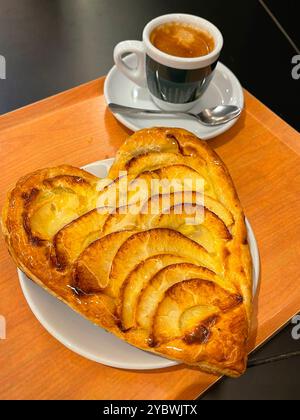 Herzförmiger Apfelkuchen und eine Tasse Kaffee. Stockfoto