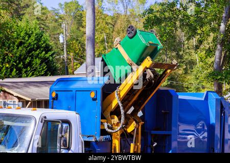 Kommunale Reinigungsdienste beseitigen Müll durch Verladen gemischter Hausmüll in Müllwagen Stockfoto