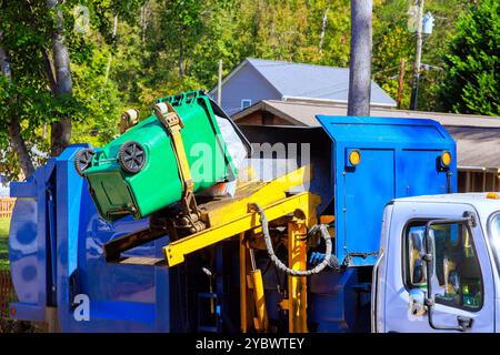 Der Müll wird von der kommunalen Reinigungsbehörde durch Verladen gemischter Hausmüll auf Müllwagen entfernt Stockfoto