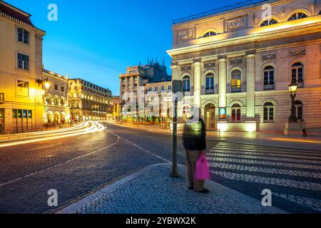 Eine Langzeitbelichtung des Domes Joao da Camara in Lissabon, Portugal, mit dem beleuchteten Nationaltheater im Vordergrund während des Abends Stockfoto