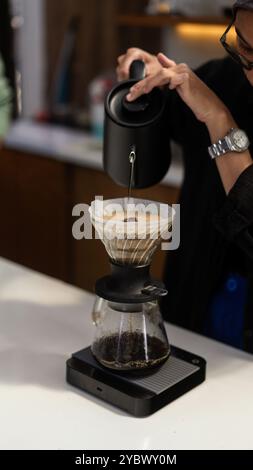 Der Barista bereite den heißen Kaffee mit der V60-Methode im Coffee Shop zu Stockfoto